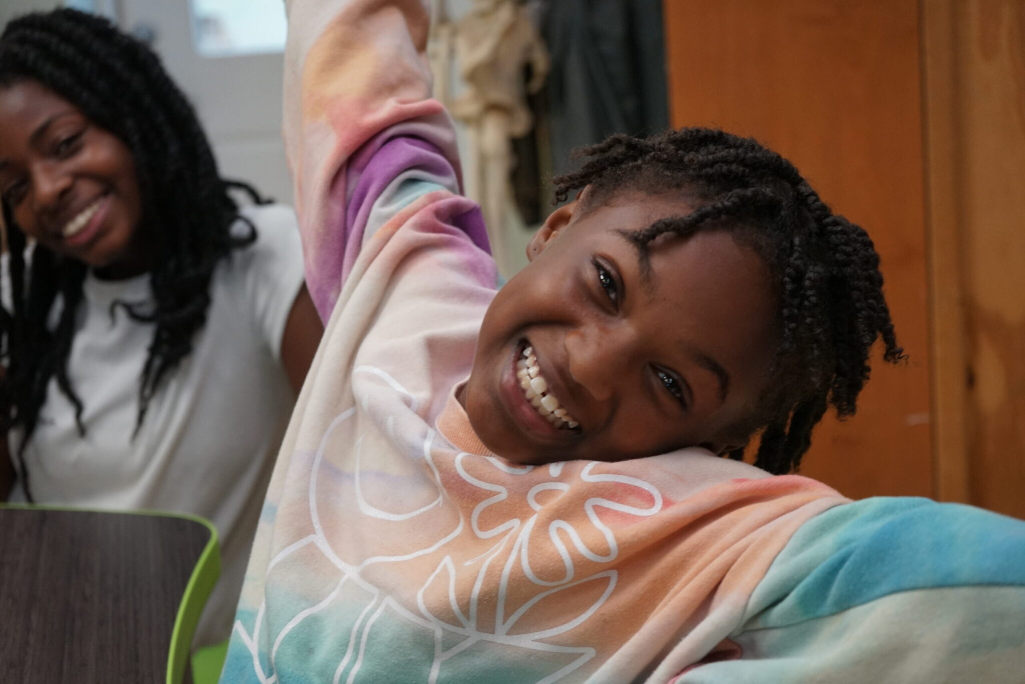 Happy child posing for photo with open arms - Corner Stone Learning Community